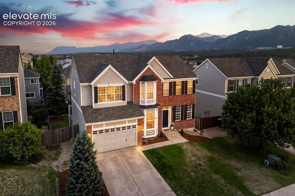 Image 1 of 48: Two-story residence featuring brick and siding facade, bay windows, attache