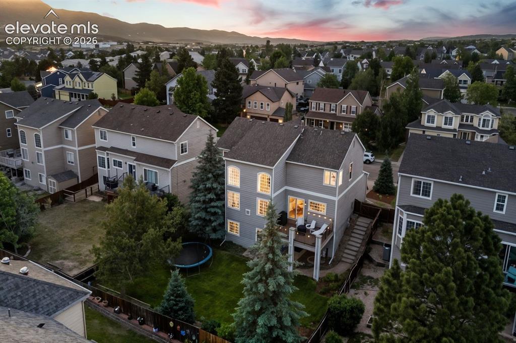 Image 45 of 48: Two-story residence with a multi-level deck, fenced yard, and established l
