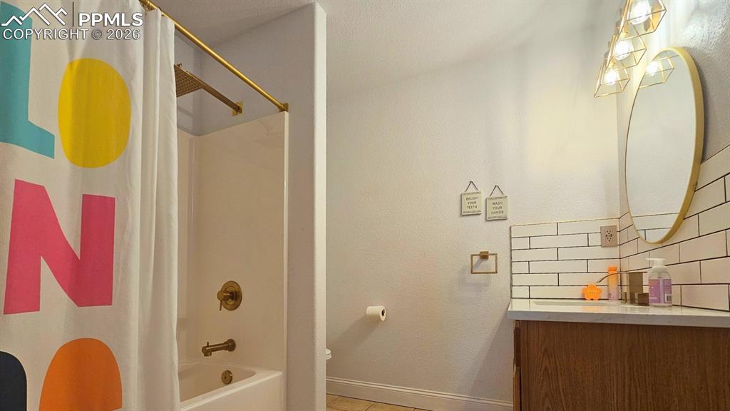 Image 24 of 41: Bathroom 3 - new quartz countertops, lighting, mirror, backsplash, faucets,