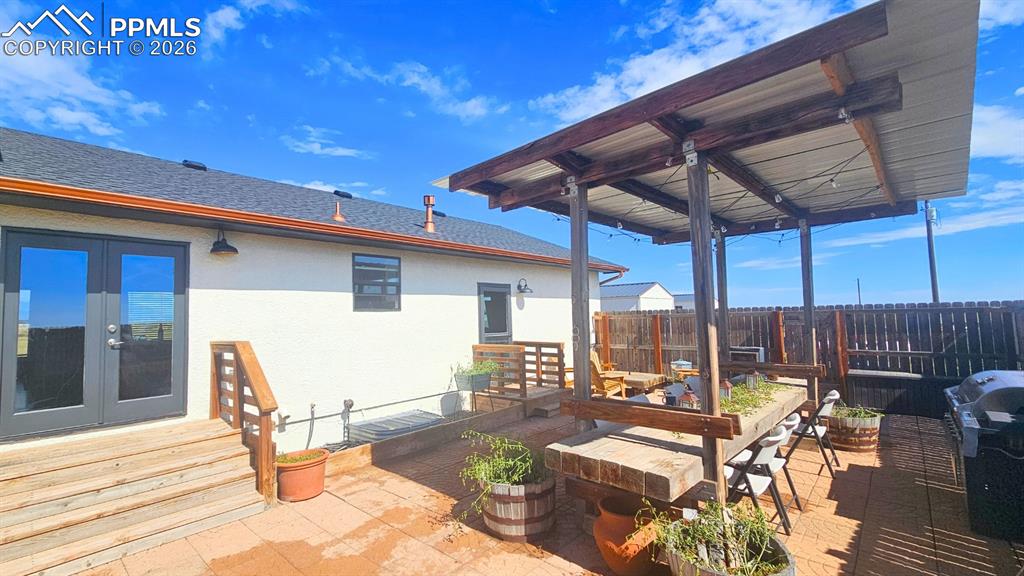Image 25 of 41: Outdoor Area with Massive Deck with Pavers, Cedar Table, Cedar Fencing, Fac