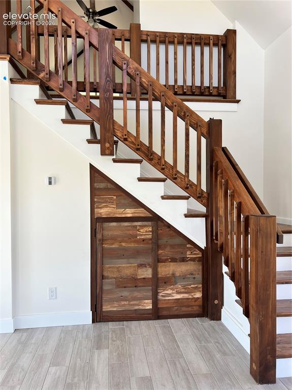 Image 13 of 43: Wood-finish flooring, custom wood staircase with balusters, built-in under-