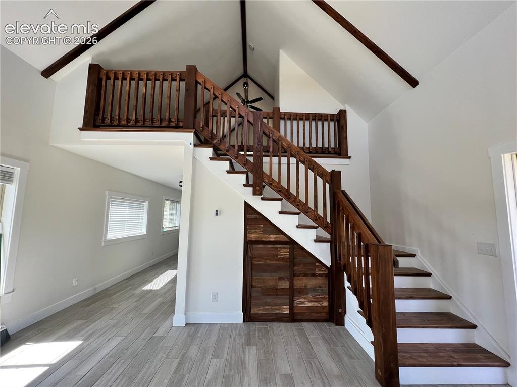 Image 14 of 43: Vaulted ceiling with exposed beams, wood-finish flooring, wood staircase wi