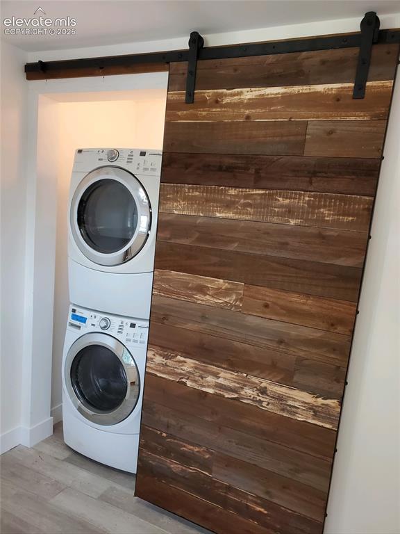 Image 18 of 43: Wood-finish barn door with exposed black metal hardware