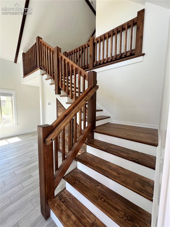 Image 20 of 43: Staircase featuring rich wood-finish treads and balusters, white risers, an