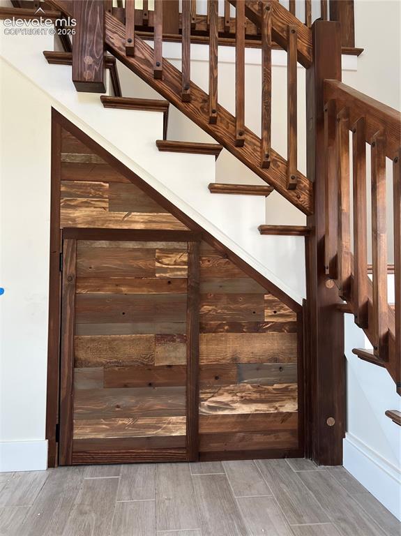 Image 21 of 43: Hardwood staircase with traditional balusters, featuring under-stair storag