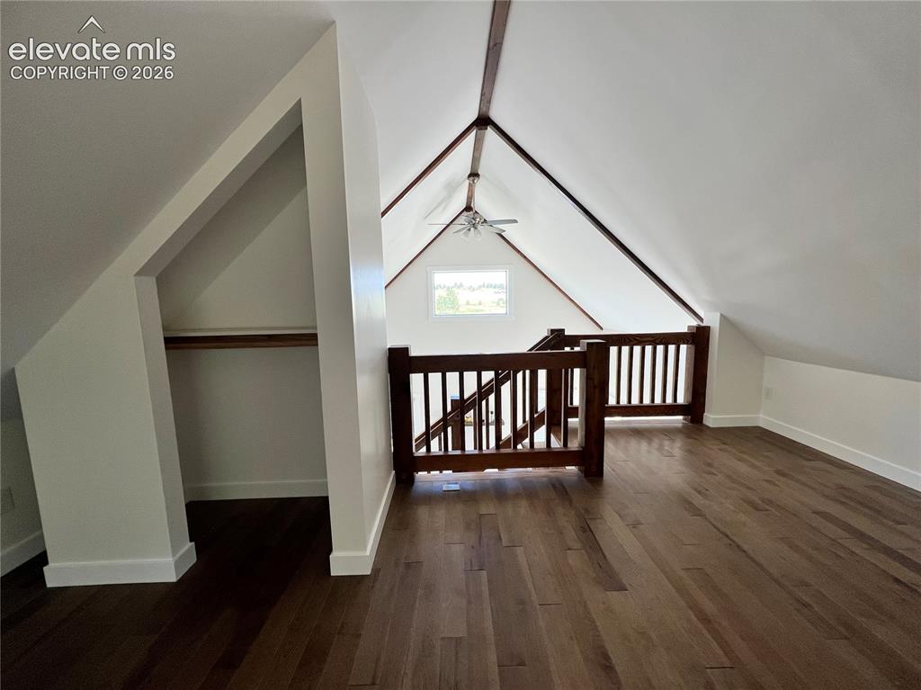 Image 22 of 43: Vaulted ceilings with exposed beams, rich wood-finish flooring, built-in st