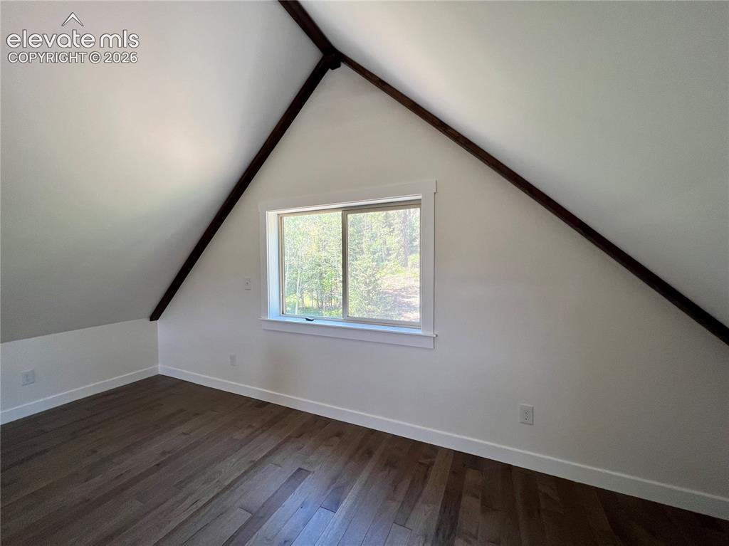 Image 23 of 43: Wood-finish flooring, white walls, and a window with white trim