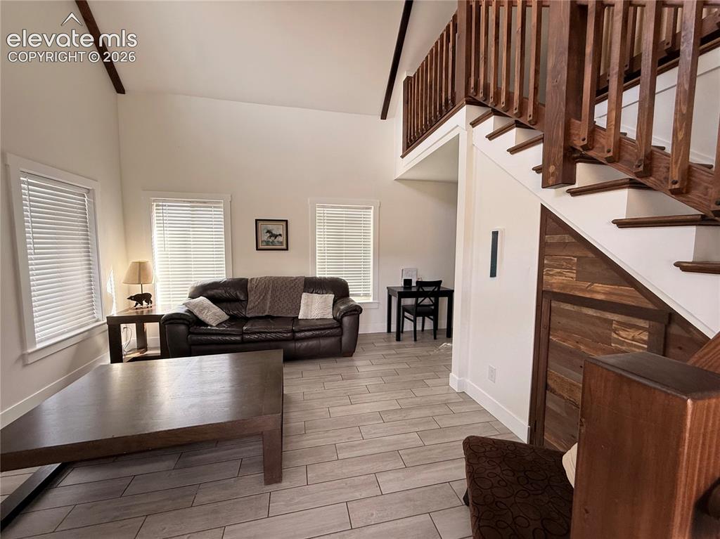 Image 29 of 43: Vaulted ceiling, open wood staircase with balusters, wood-finish flooring,