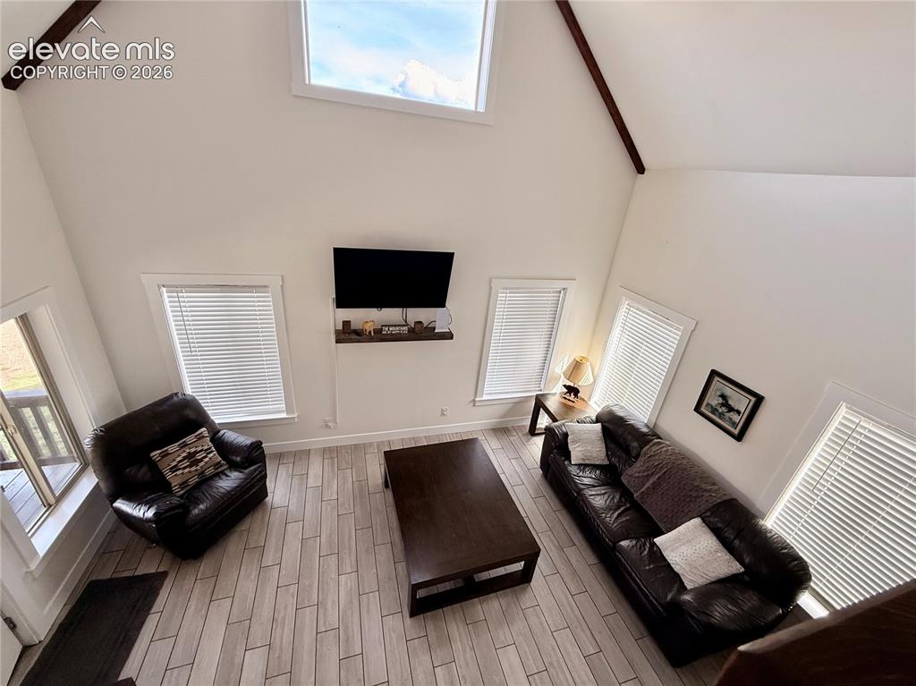Image 33 of 43: Vaulted ceilings with exposed beams, high transom window, light wood-finish