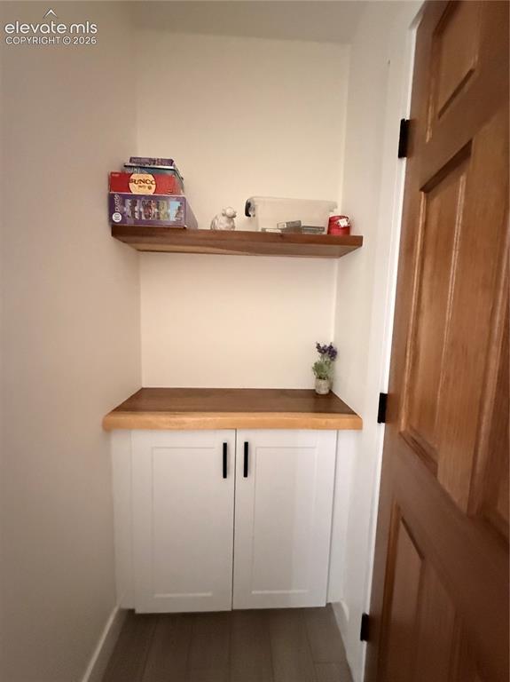 Image 35 of 43: Built-in cabinetry with white shaker-style doors, wood-finish countertop, a