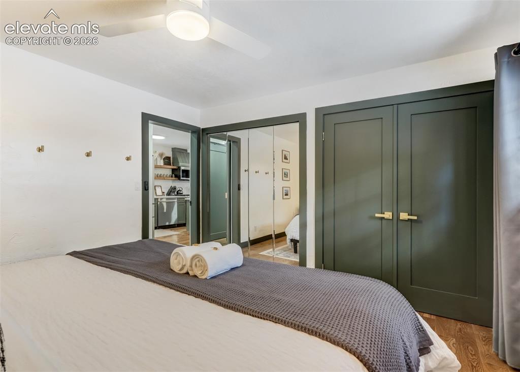 Image 23 of 49: In this bedroom there is a closet with full size mirror doors and large wid
