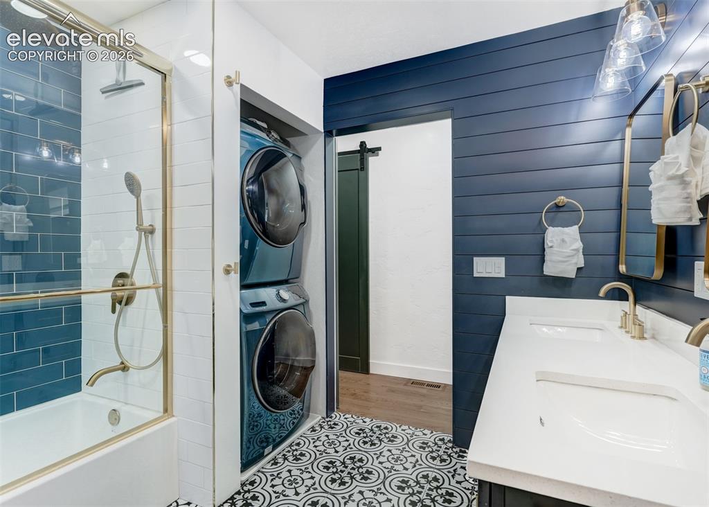 Image 46 of 49: The laundry area is located inside the bathroom. With A large capacity wash