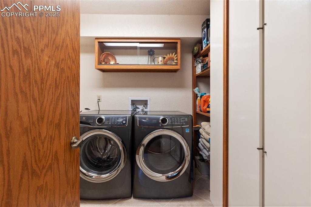Image 35 of 49: Main level laundry with sink, closet and shelving