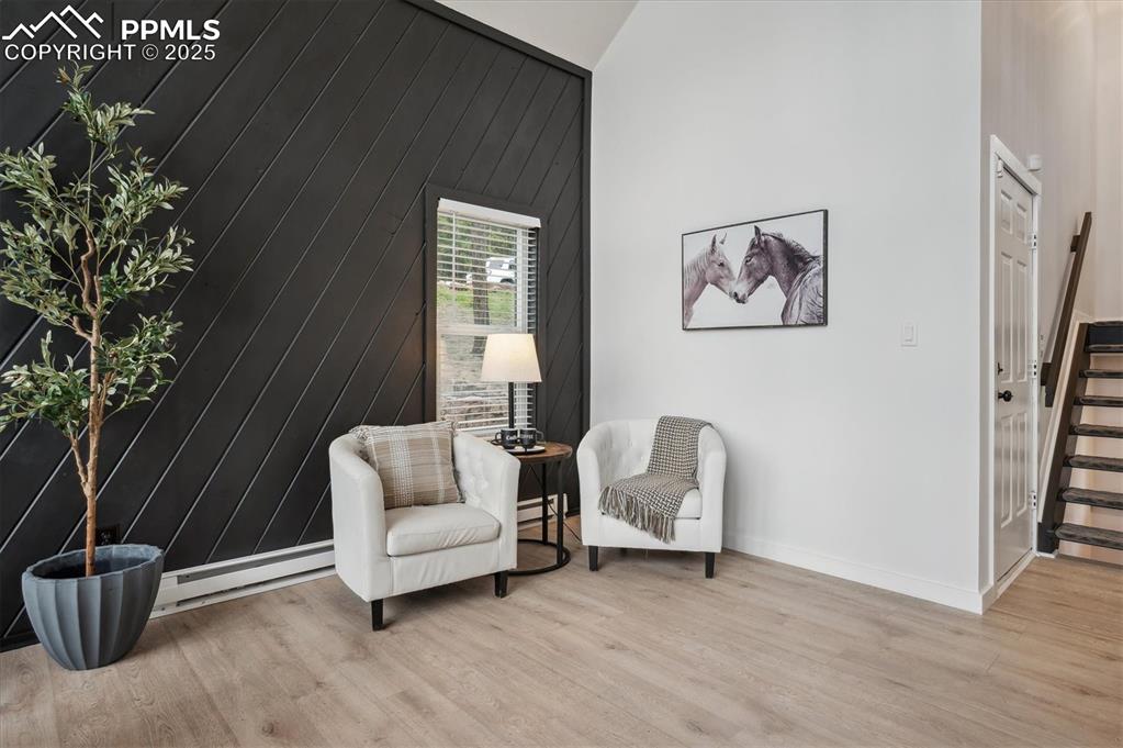 Image 11 of 44: Sitting room featuring baseboard heating, stairs, light wood finished floor