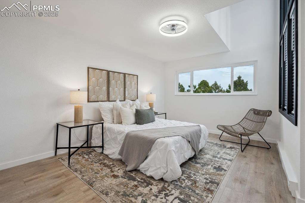 Image 14 of 44: Bedroom with wood finished floors and baseboards