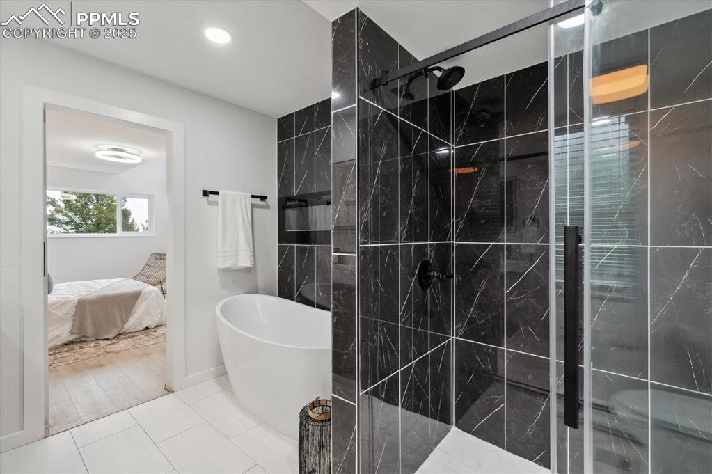 Image 17 of 44: Ensuite bathroom featuring a freestanding bath, a shower stall, and recesse