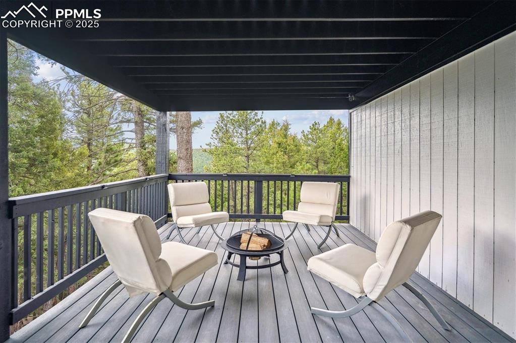Image 27 of 44: Wooden terrace with an outdoor fire pit