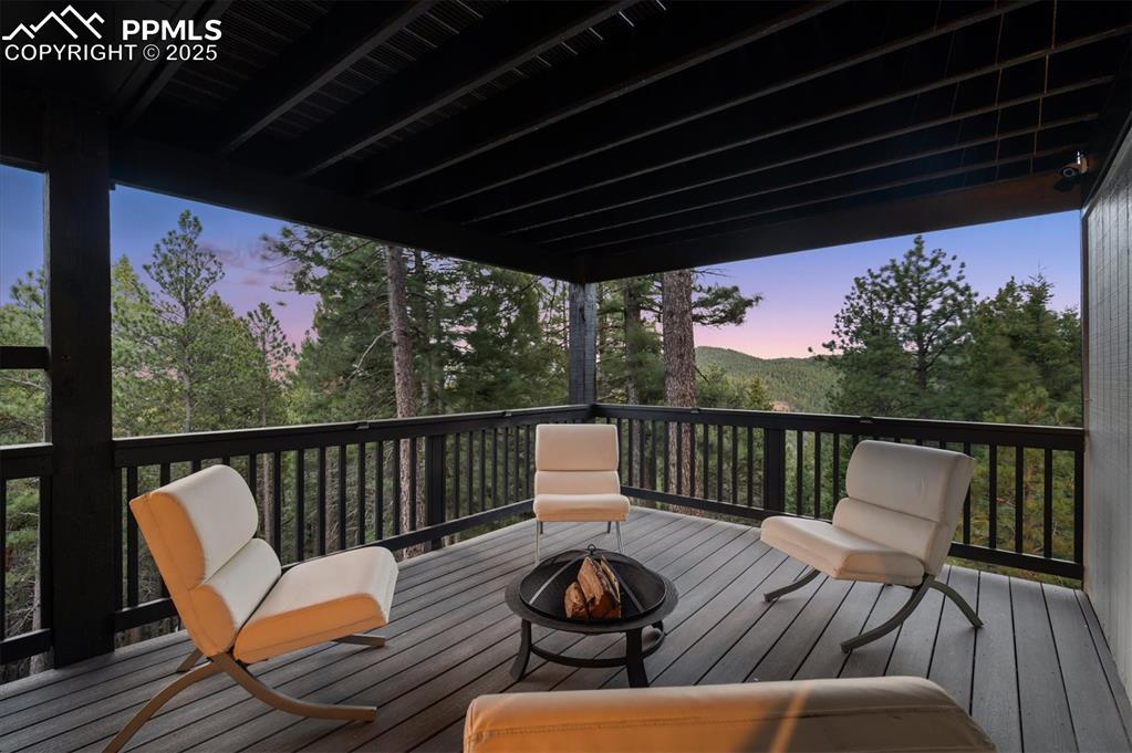 Image 32 of 44: Deck at dusk with an outdoor fire pit