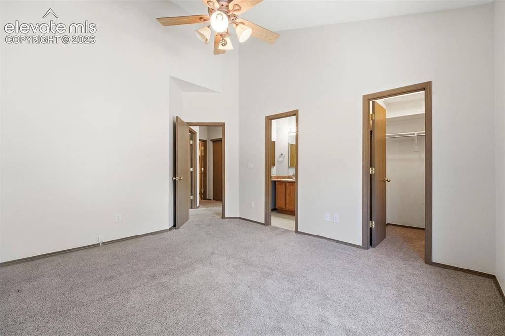 Image 12 of 30: Spacious room featuring vaulted ceilings, neutral-toned carpet, and a ceili