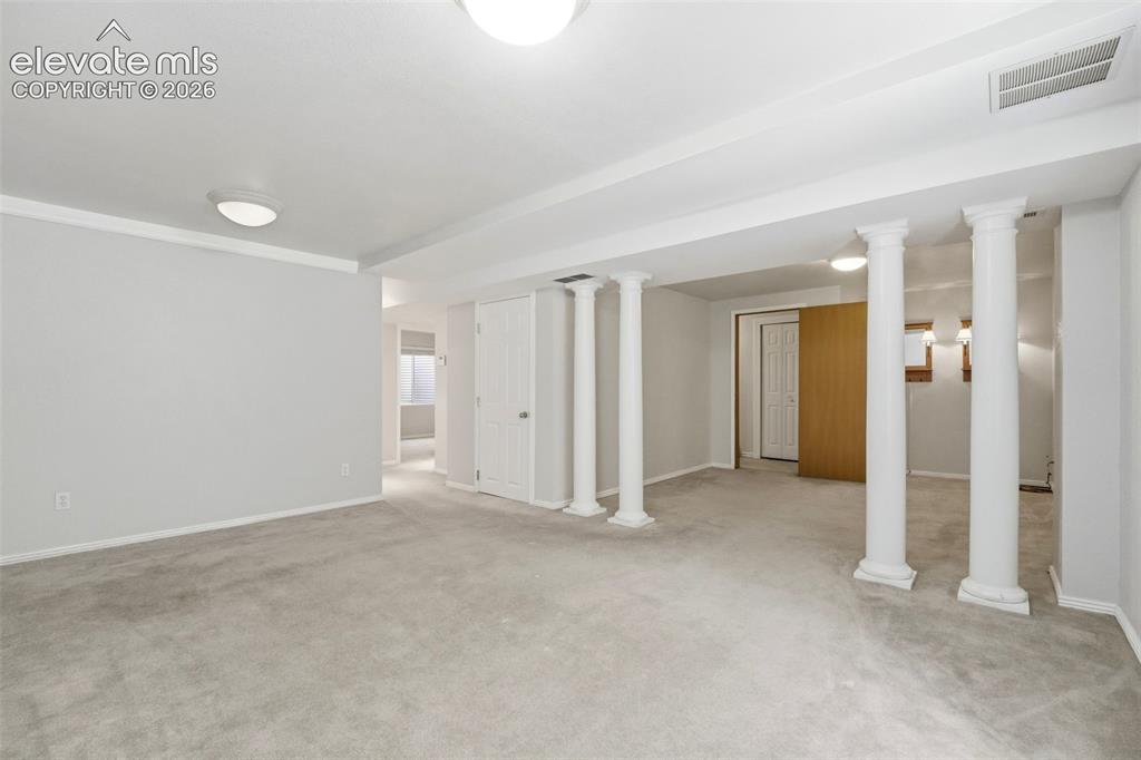 Image 15 of 30: Spacious interior room featuring carpet flooring, recessed lighting, and ar