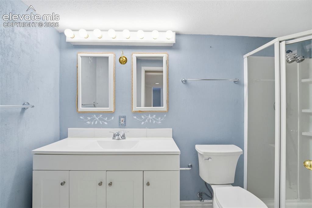 Image 18 of 30: Bathroom featuring a white vanity with integrated sink, dual framed mirrors