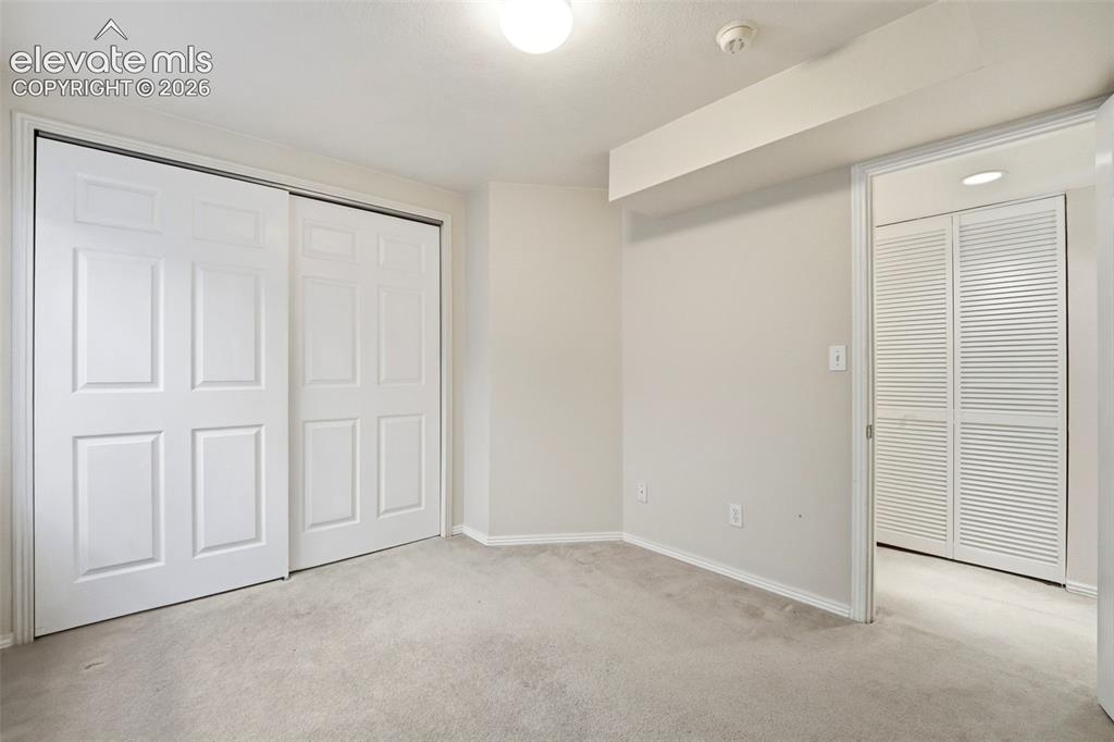 Image 19 of 30: Neutral tone wall paint with carpet flooring, featuring a six-panel bi-fold