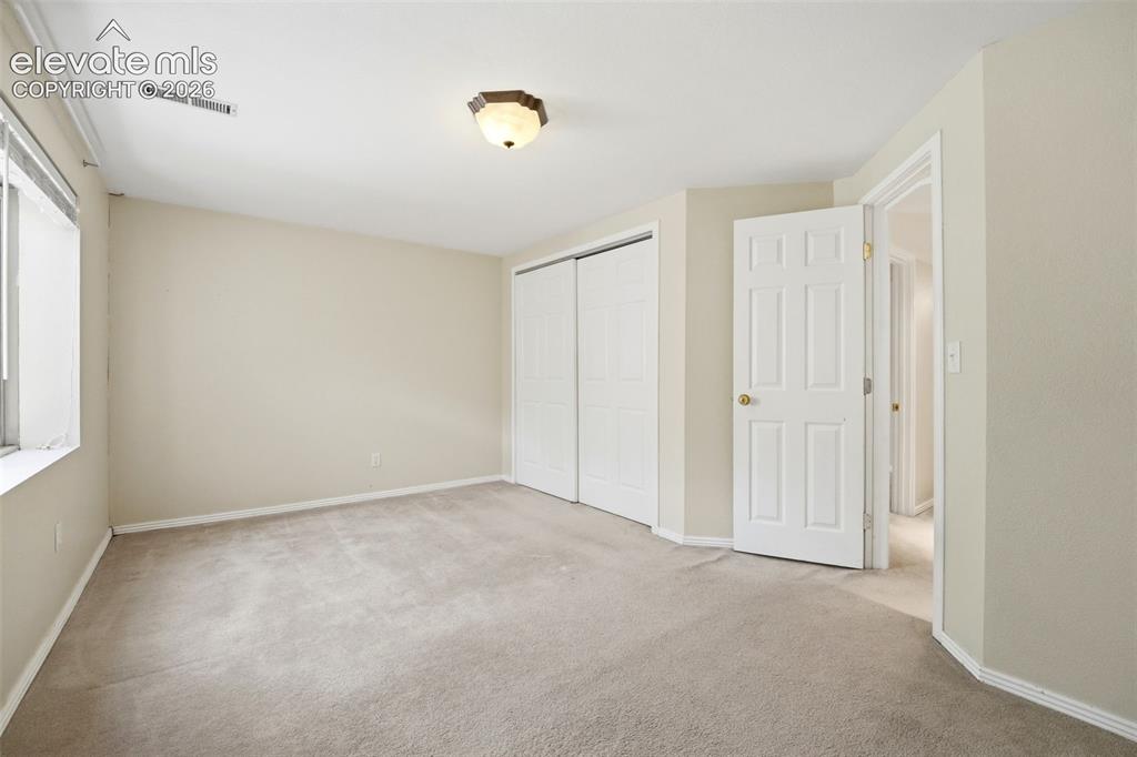 Image 20 of 30: Carpeted room featuring a ceiling-mounted light fixture, dual sliding close