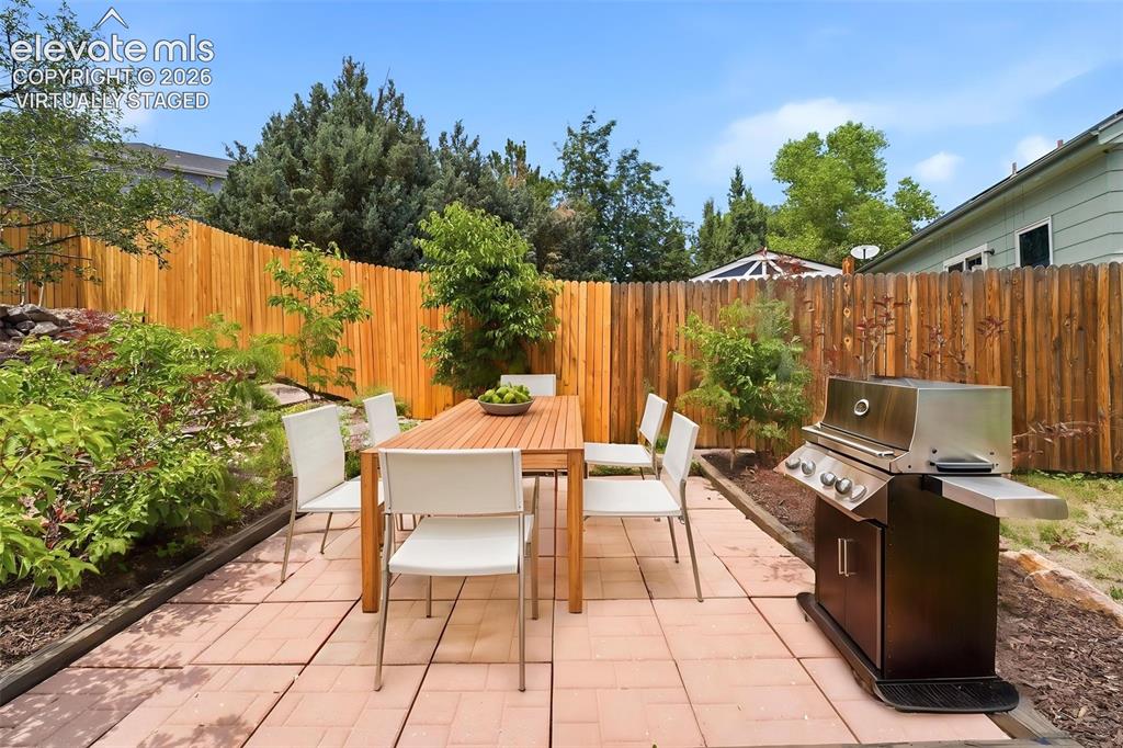 Image 24 of 30: (Virtually Staged) Patio area featuring large format pavers, a wood privacy