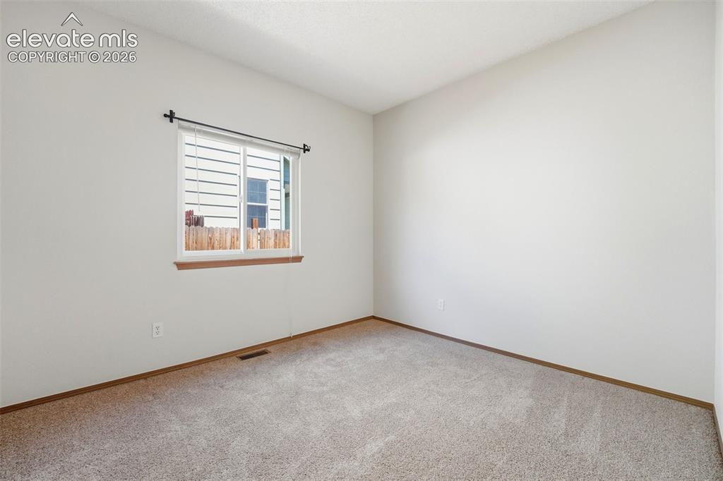 Image 8 of 30: Neutral painted walls, light-toned carpeting, wood-finish window trim, and 