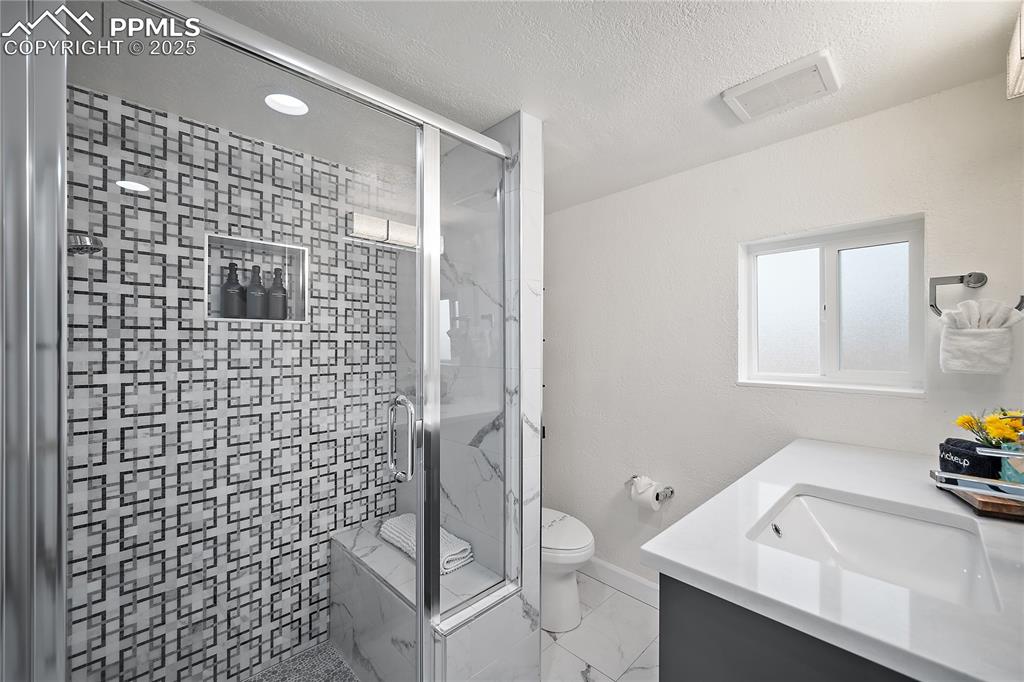 Image 14 of 47: Full bath featuring vanity, visible vents, toilet, a textured ceiling, and