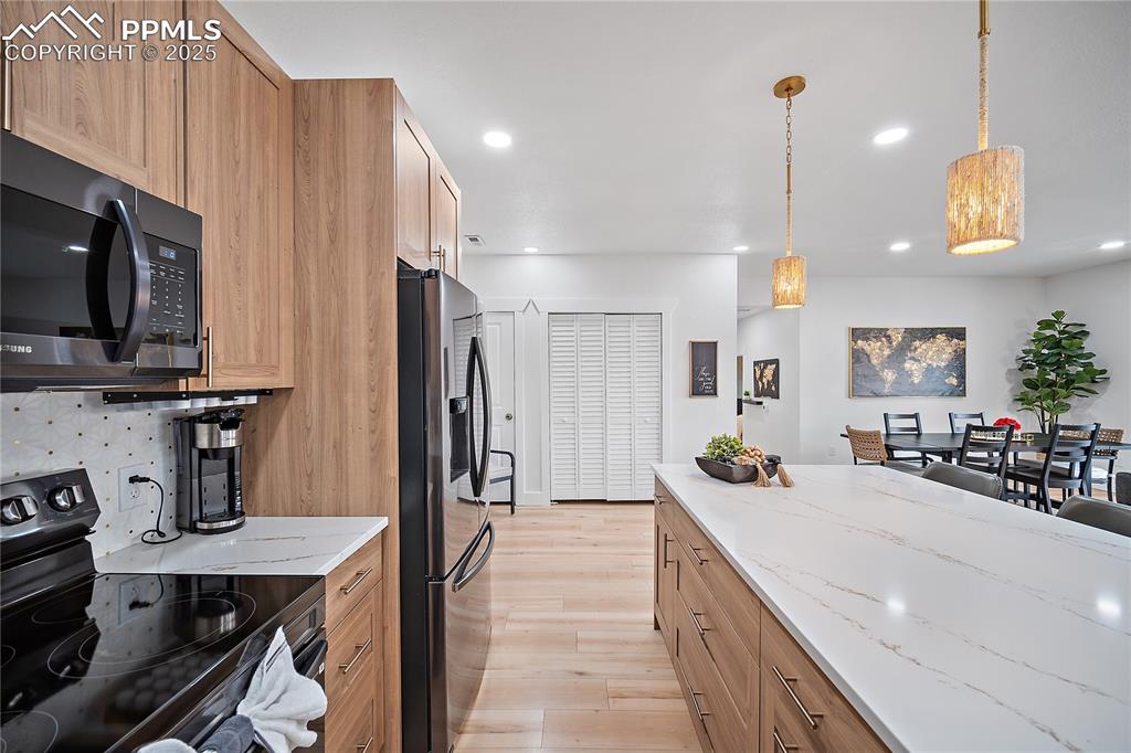 Image 25 of 47: Kitchen featuring recessed lighting, stainless steel fridge, black electric