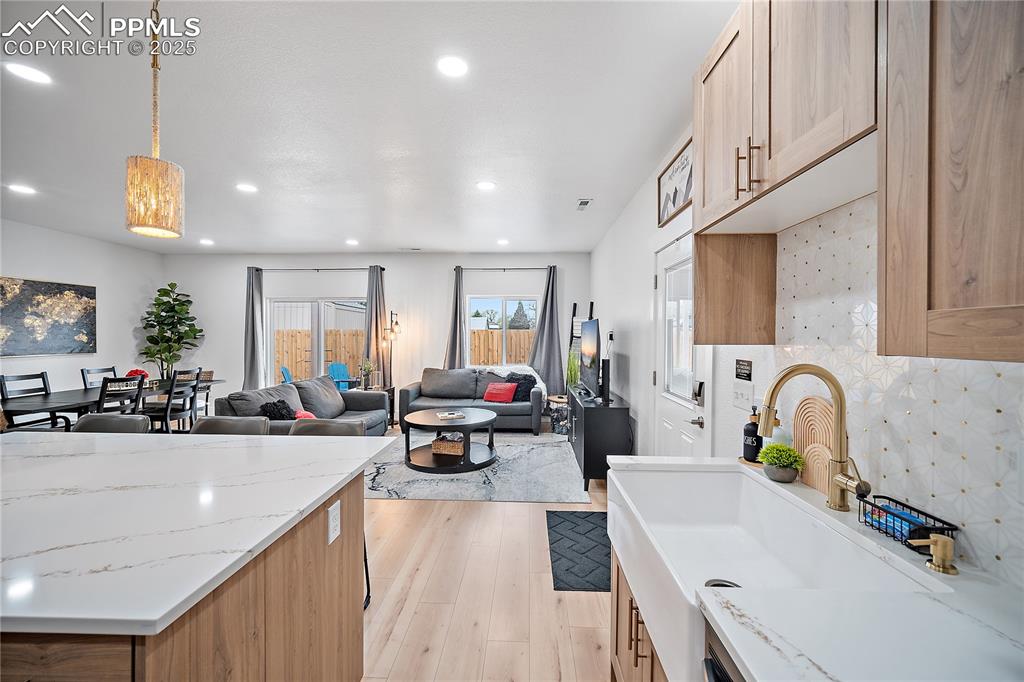 Image 26 of 47: Kitchen with open floor plan, recessed lighting, light stone counters, a si