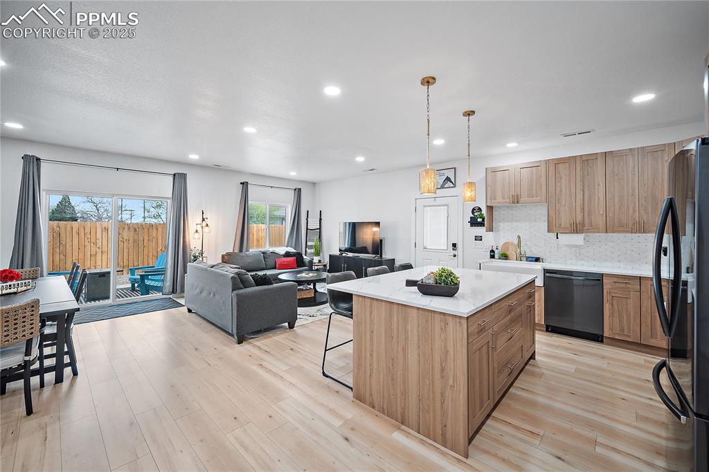 Image 27 of 47: Kitchen featuring a kitchen breakfast bar, freestanding refrigerator, open