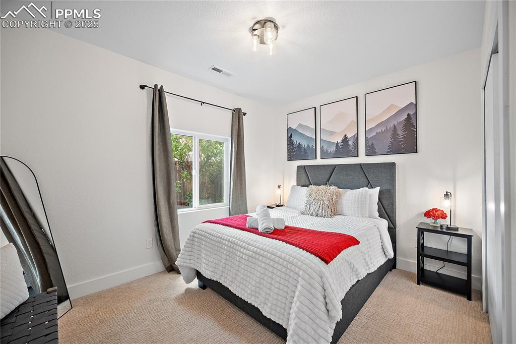 Image 32 of 47: Bedroom with visible vents, carpet, and baseboards