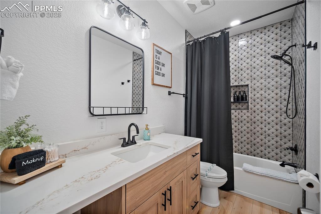 Image 34 of 47: Full bath with visible vents, vanity, wood finished floors, toilet, and sho