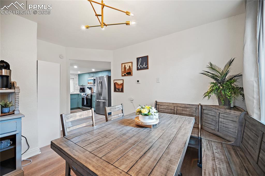 Image 6 of 47: Dining room with recessed lighting, an inviting chandelier, and light wood
