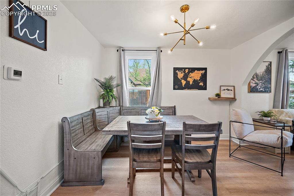 Image 7 of 47: Dining area featuring light wood-style floors, arched walkways, baseboards,
