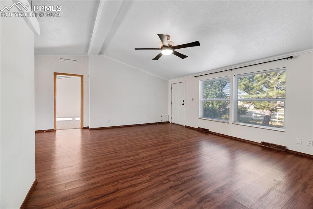 Image 11 of 46: Unfurnished room with a ceiling fan, a textured ceiling, and wood finished