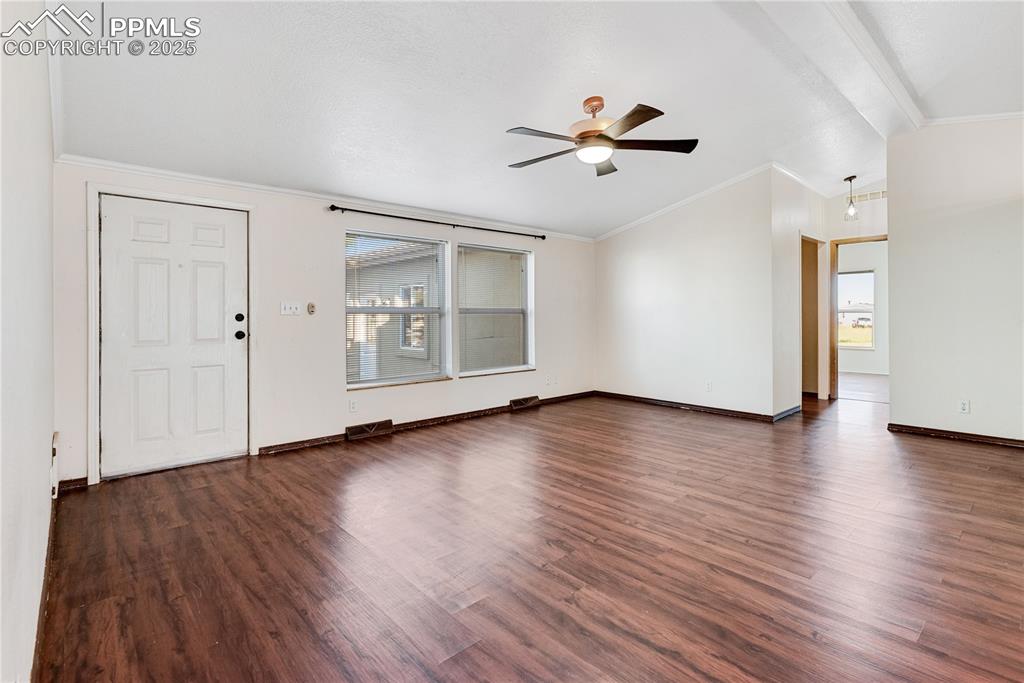 Image 12 of 46: Unfurnished living room featuring lofted ceiling, ornamental molding, ceili