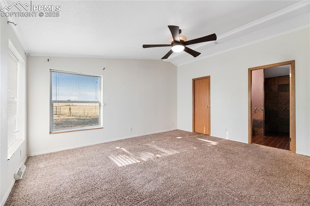 Image 15 of 46: Unfurnished bedroom with crown molding, carpet, ensuite bathroom, and ceili