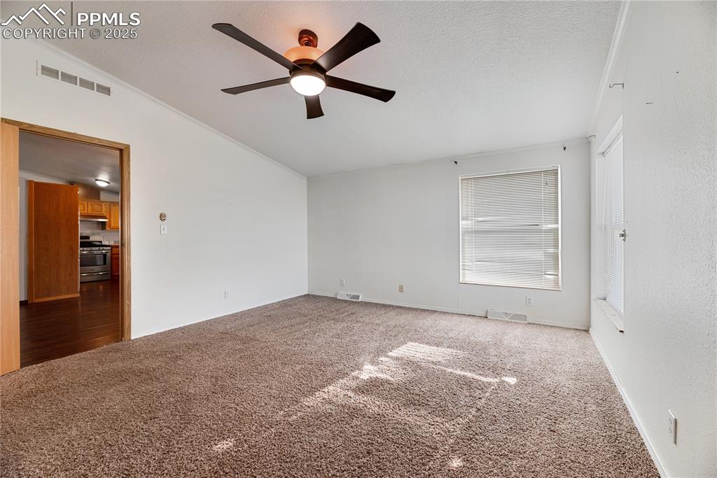 Image 17 of 46: Unfurnished room with ornamental molding, lofted ceiling, a ceiling fan, ca