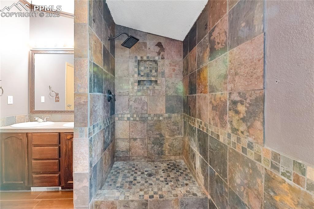 Image 20 of 46: Full bathroom featuring walk in shower, vanity, and a textured ceiling