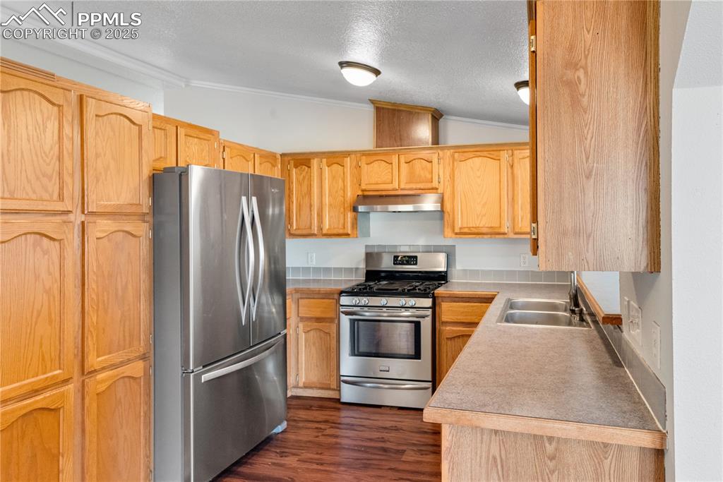 Image 22 of 46: Kitchen with appliances with stainless steel finishes, lofted ceiling, a te