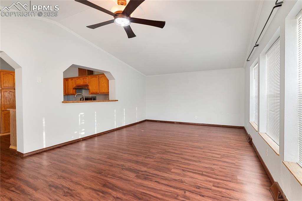 Image 25 of 46: Unfurnished living room featuring lofted ceiling, dark wood finished floors