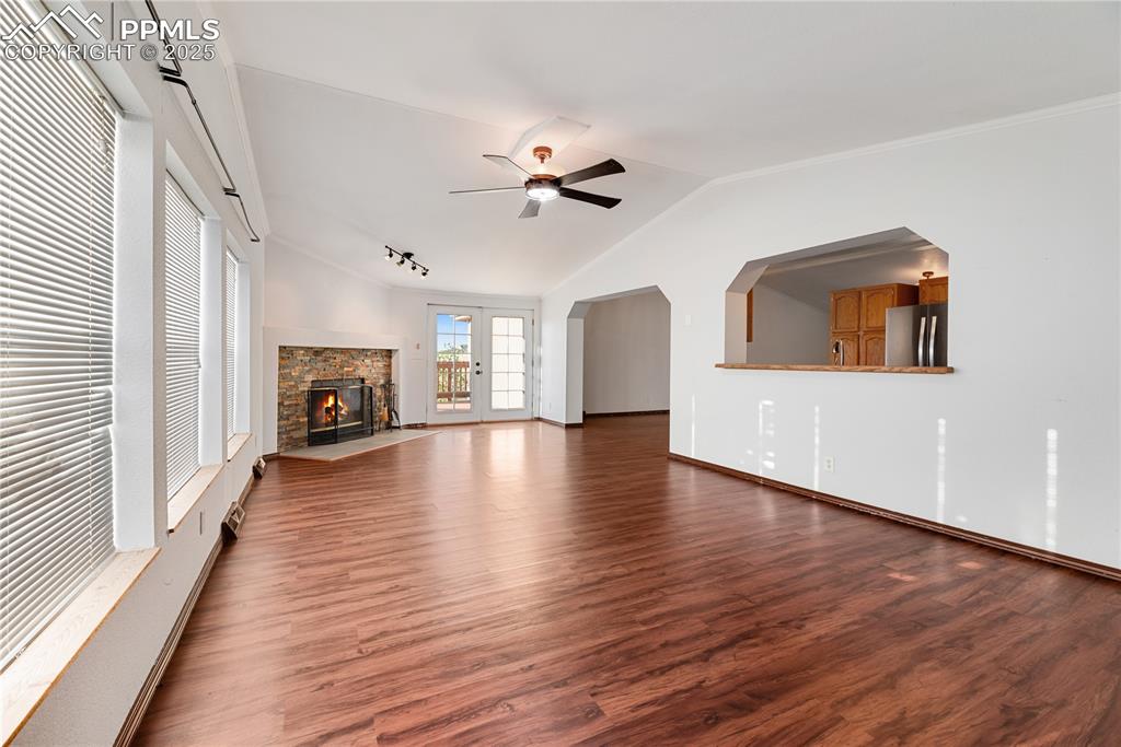 Image 26 of 46: Unfurnished living room with wood finished floors, ceiling fan, lofted ceil