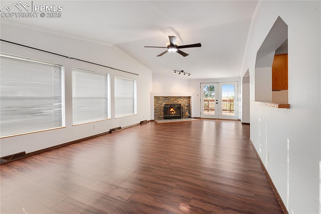 Image 27 of 46: Unfurnished living room with a ceiling fan, lofted ceiling, rail lighting,