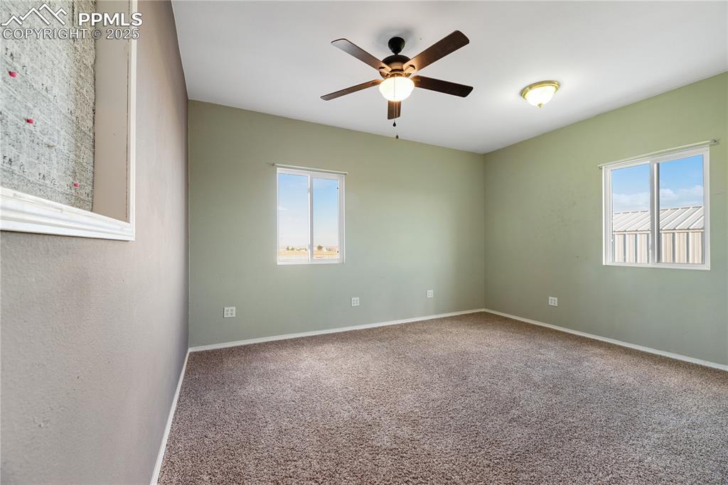 Image 37 of 46: Spare room featuring ceiling fan, plenty of natural light, and carpet