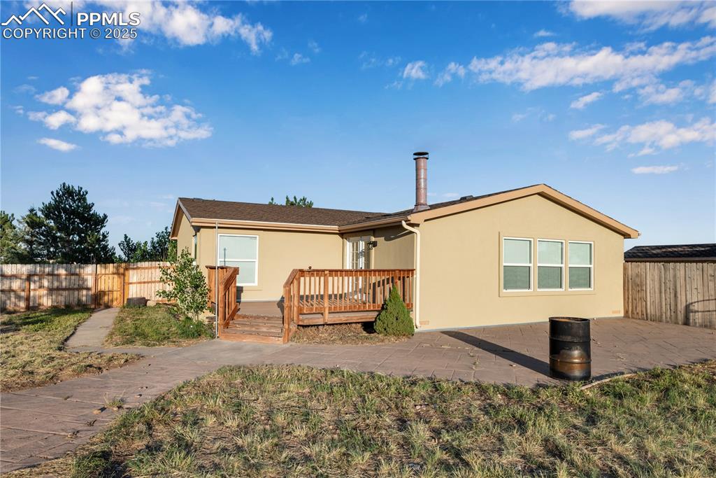 Image 7 of 46: Back of property featuring stucco siding, a wooden deck, and a patio area
