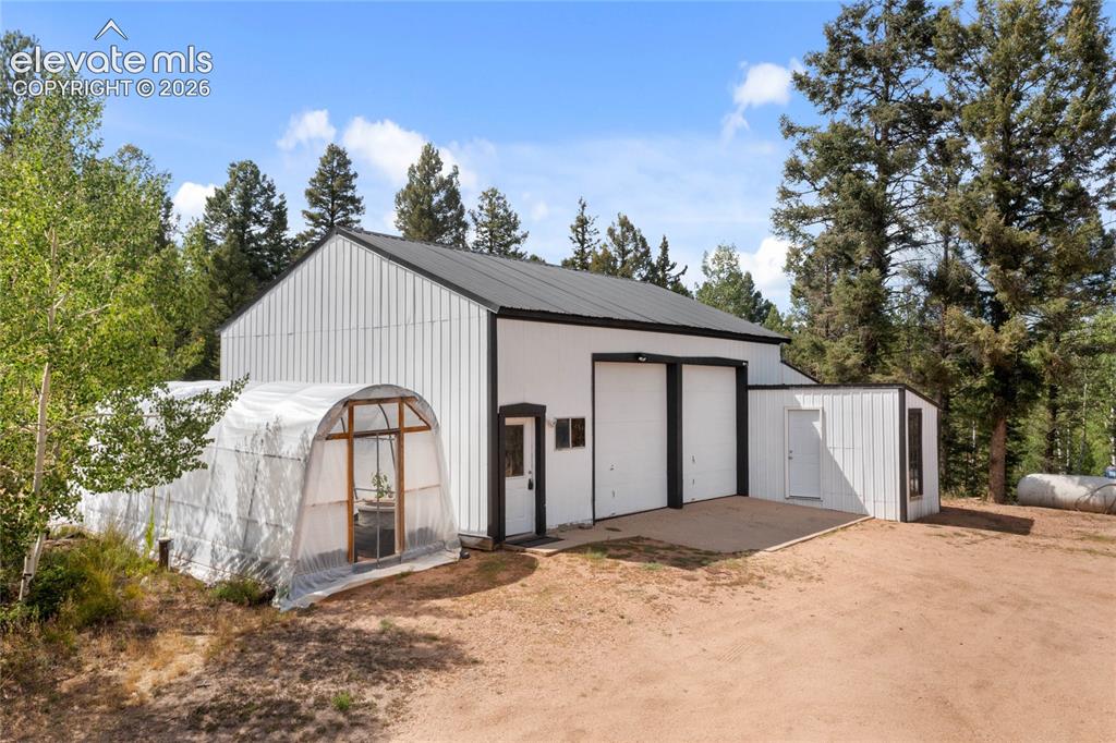 Image 3 of 46: Oversized detached garage/shop with RV doors and multiple workshops & stora