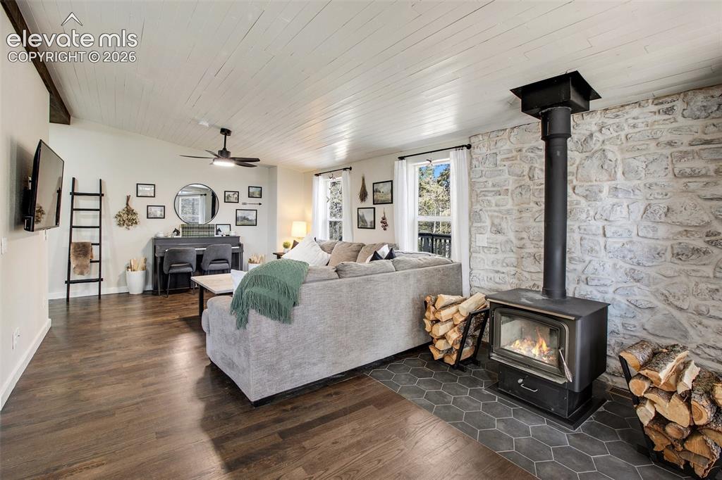 Image 4 of 46: Main level living room with wood burning fireplace